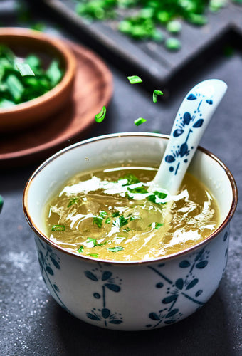 Bowl of anti-inflammatory chicken soup with turmeric, ginger, and fresh herbs