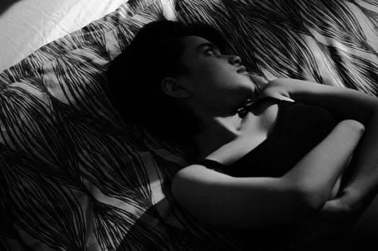 A woman resting peacefully with a white flower, representing natural herbal sleep support